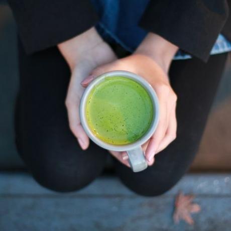 een kopje gezette hete matcha-thee, die je holistische gezondheid in de loop van de tijd kan helpen verbeteren