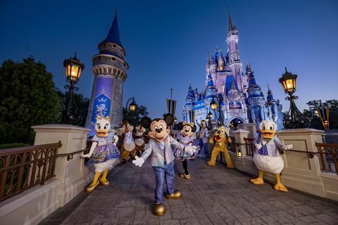 Mickey Mouse en vrienden dragen hun 50e verjaardag glinsterende mode terwijl ze poseren voor het kasteel van Assepoester in Magic Kingdom Park